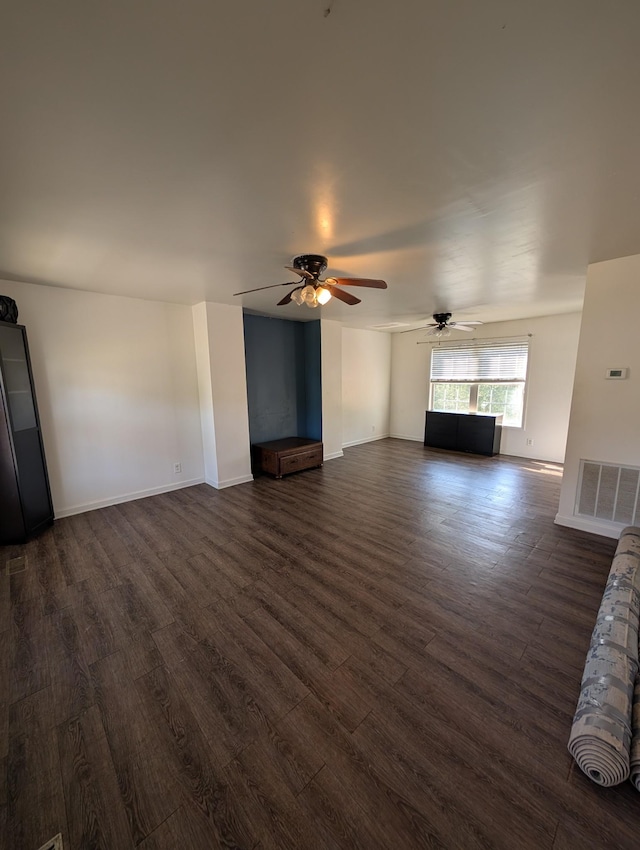 unfurnished living room featuring visible vents, ceiling fan, baseboards, and dark wood finished floors