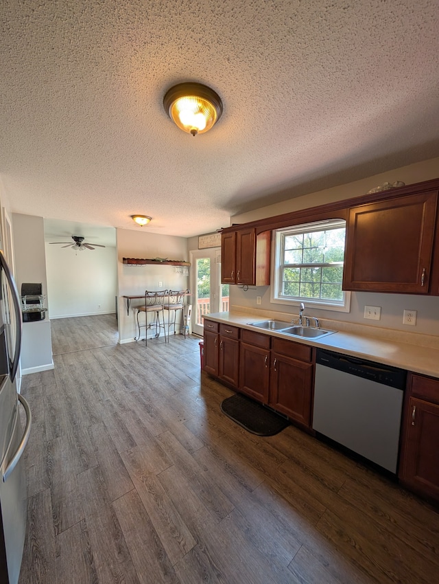 kitchen with ceiling fan, light hardwood / wood-style flooring, sink, dishwasher, and a textured ceiling