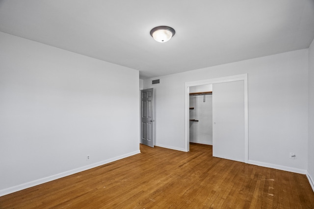 unfurnished bedroom with a closet and hardwood / wood-style flooring