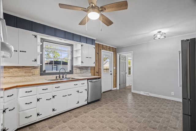 kitchen with decorative backsplash, white cabinets, stainless steel appliances, and sink