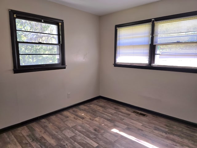 unfurnished room with dark hardwood / wood-style flooring