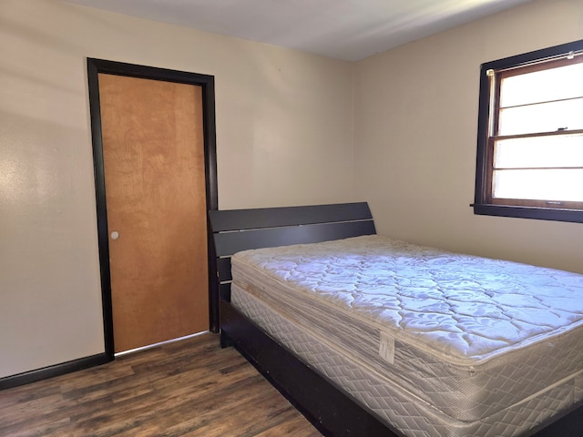 bedroom with dark hardwood / wood-style floors