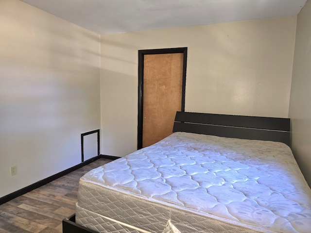 bedroom with dark hardwood / wood-style flooring