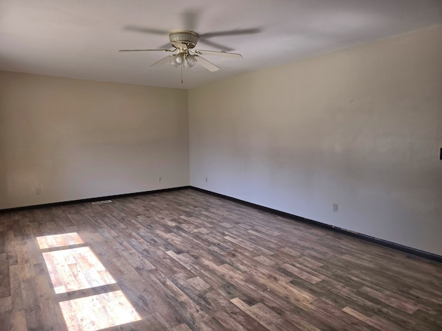 empty room featuring dark wood-type flooring and ceiling fan