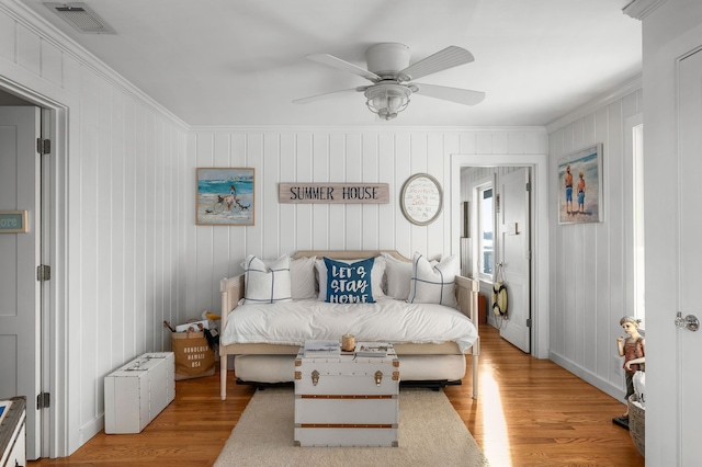 bedroom with ceiling fan, light wood-type flooring, and crown molding