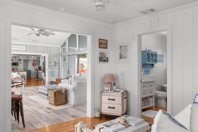 living room featuring ceiling fan, wood-type flooring, and ornamental molding