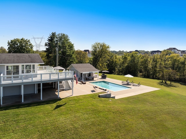 view of swimming pool with a lawn, a patio area, a wooden deck, and an outdoor structure