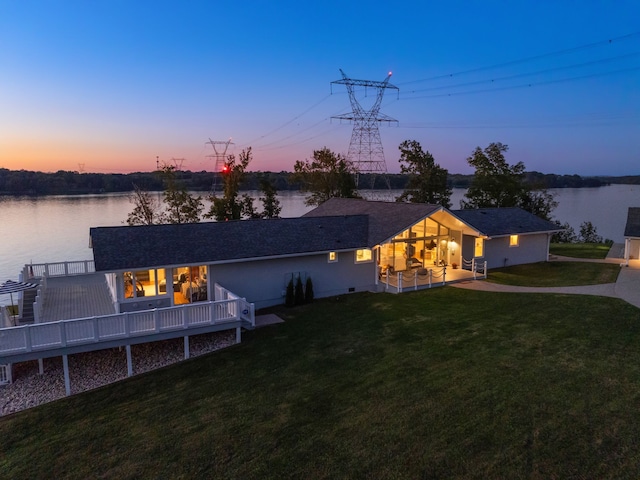 view of front of house with a deck with water view and a yard