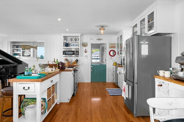 kitchen featuring wooden counters, stainless steel appliances, crown molding, white cabinets, and light hardwood / wood-style floors