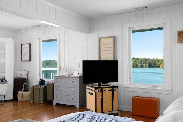 bedroom featuring multiple windows, dark hardwood / wood-style flooring, and ornamental molding