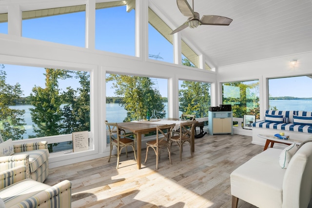 sunroom featuring lofted ceiling with beams and a water view