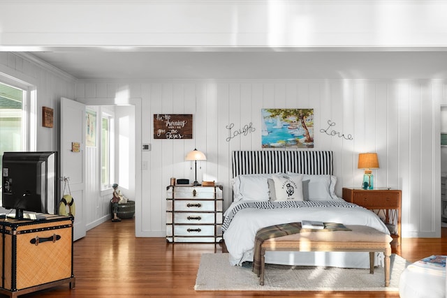 bedroom featuring crown molding and dark wood-type flooring