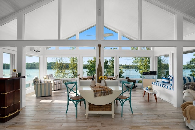 sunroom with a wealth of natural light, a water view, and lofted ceiling with beams