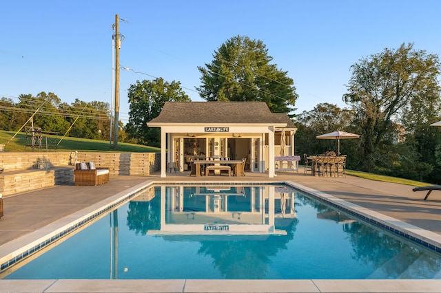 view of swimming pool with a patio area and an outdoor structure