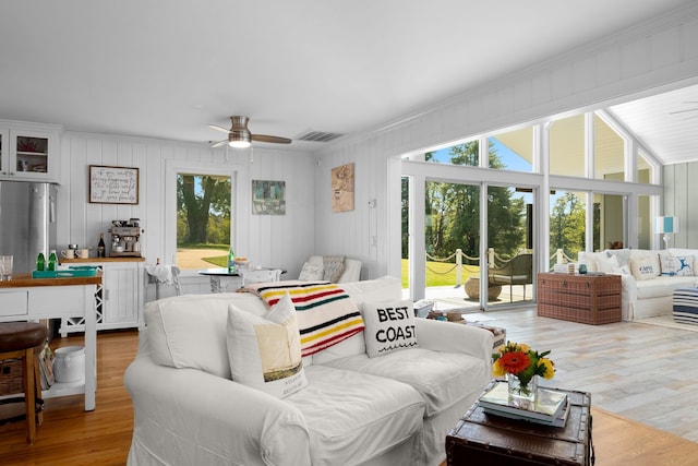 living room with ceiling fan, a healthy amount of sunlight, light hardwood / wood-style floors, and crown molding