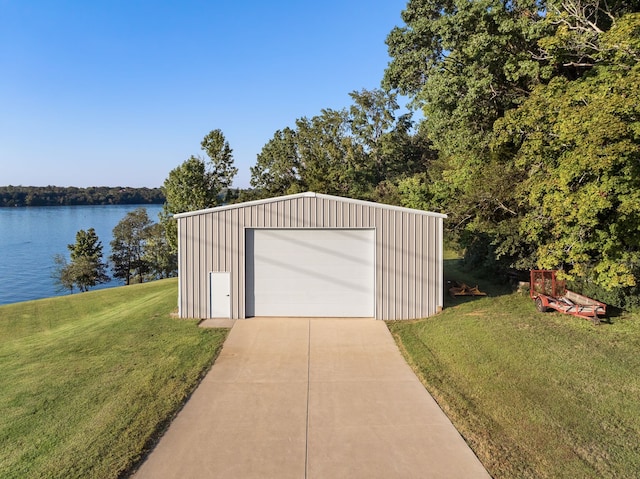 garage with a water view and a lawn