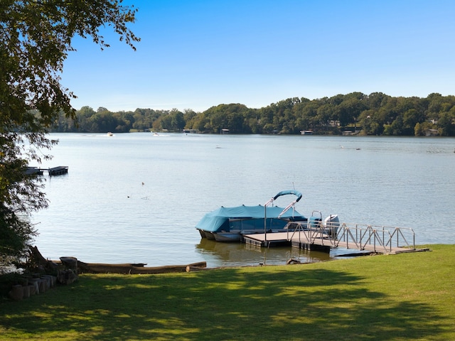 view of dock featuring a water view and a yard