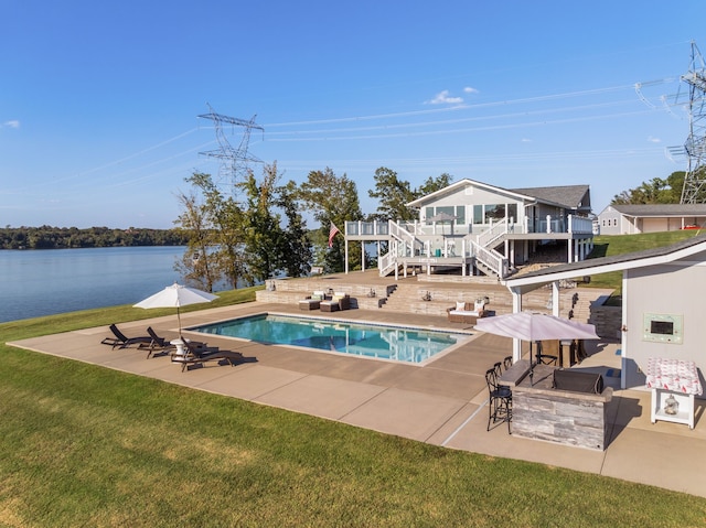 view of swimming pool with a lawn, a deck with water view, an outdoor bar, and a patio