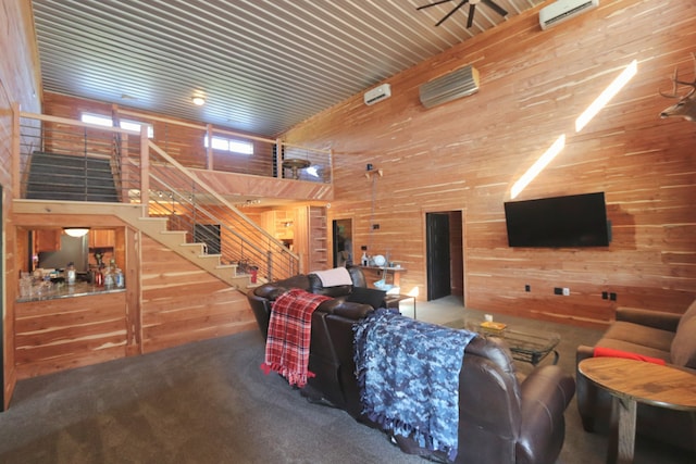 carpeted living room featuring a towering ceiling, a wall mounted AC, and wooden walls