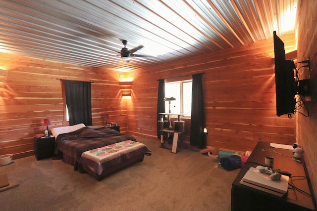 bedroom with ceiling fan, wood walls, and carpet flooring