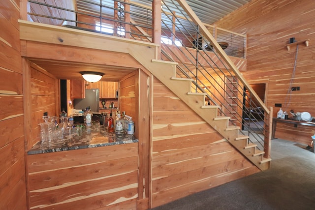 stairs with wood walls and carpet flooring