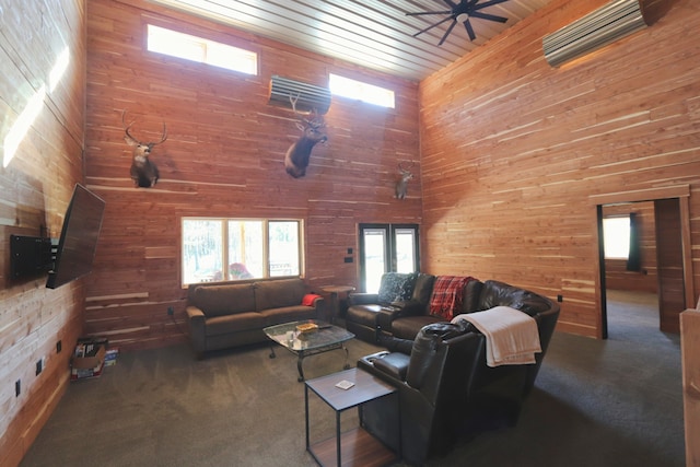 carpeted living room with wood ceiling, a high ceiling, wooden walls, and ceiling fan