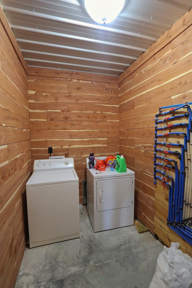 washroom with wooden walls and washer and dryer