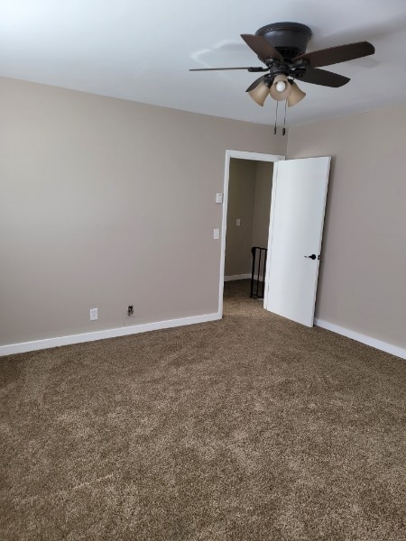 carpeted spare room with ceiling fan