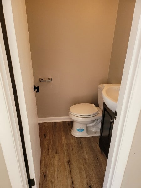 bathroom with hardwood / wood-style flooring, vanity, and toilet