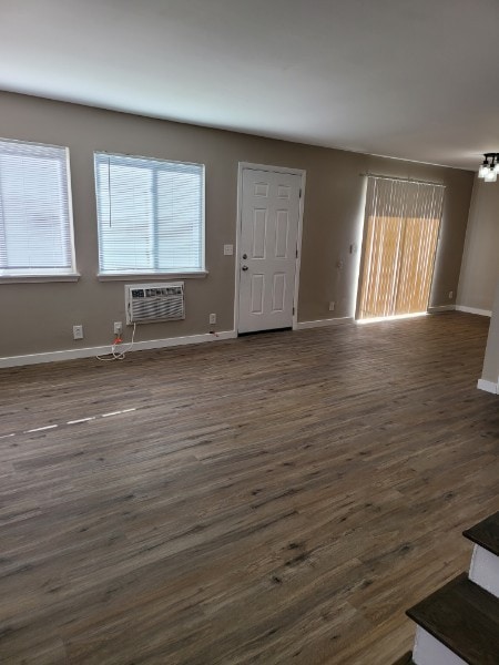 interior space featuring dark wood-type flooring and a wall mounted AC