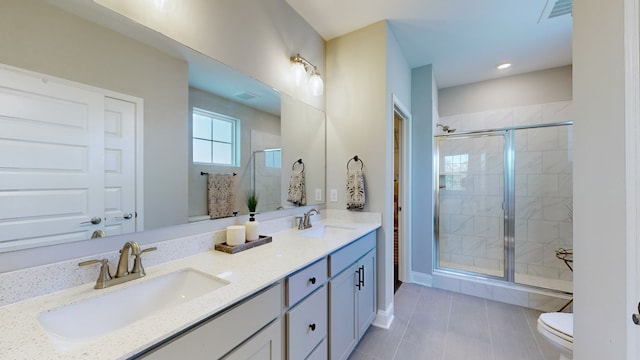 bathroom with an enclosed shower, tile patterned floors, vanity, and toilet