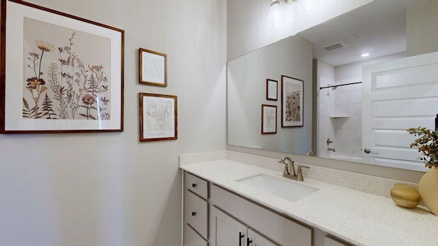 bathroom featuring tiled shower / bath combo and vanity