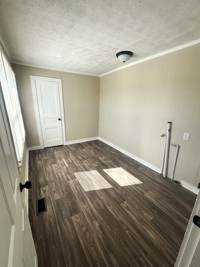 unfurnished room featuring ornamental molding, a textured ceiling, and dark hardwood / wood-style flooring