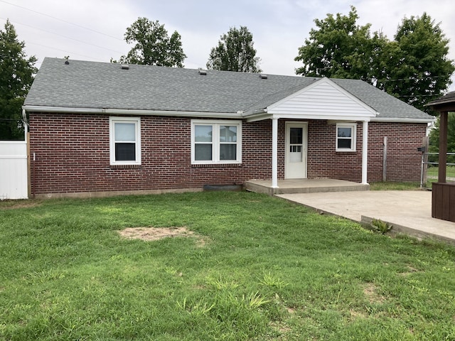 back of property with a yard and a patio