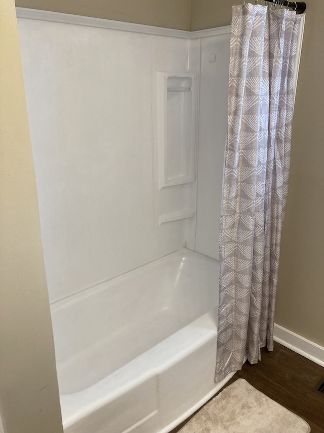 bathroom featuring wood-type flooring and shower / bath combo