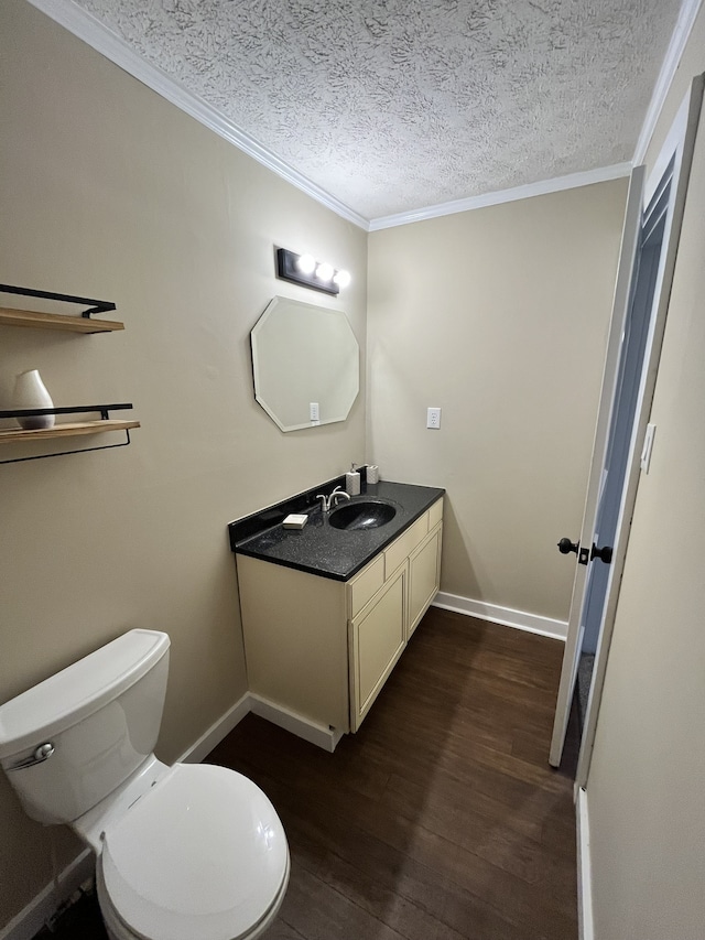 bathroom featuring vanity, toilet, a textured ceiling, crown molding, and hardwood / wood-style floors