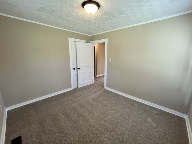 unfurnished room with crown molding, carpet floors, and a textured ceiling