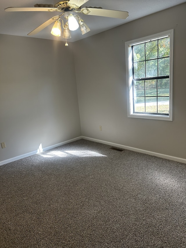 carpeted spare room with ceiling fan