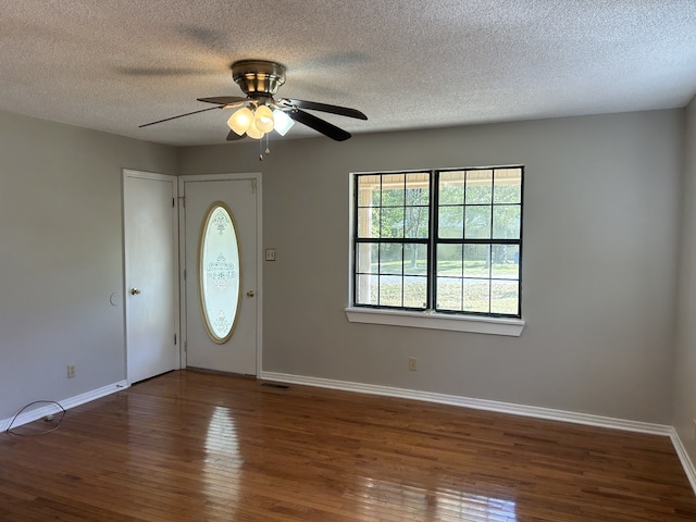 foyer entrance with ceiling fan, dark hardwood / wood-style flooring, and a textured ceiling