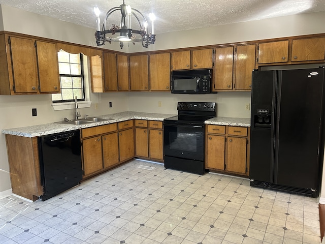 kitchen featuring hanging light fixtures, sink, a textured ceiling, black appliances, and an inviting chandelier