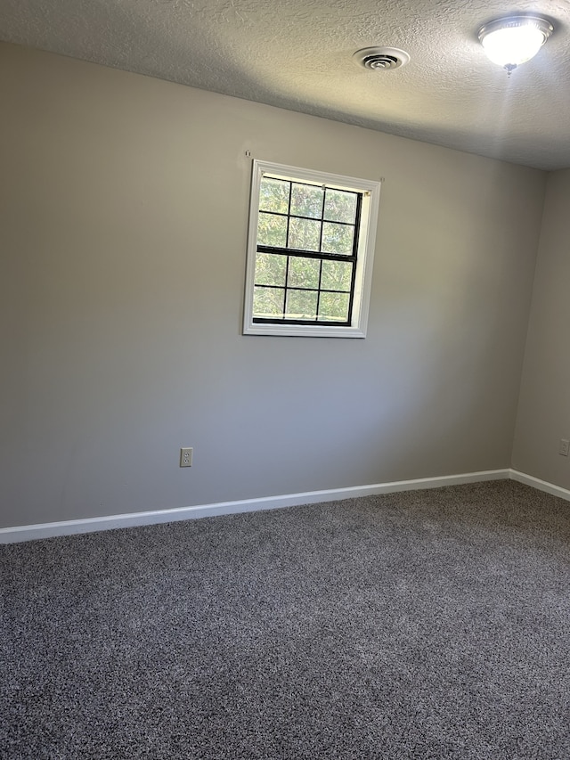 carpeted spare room with a textured ceiling