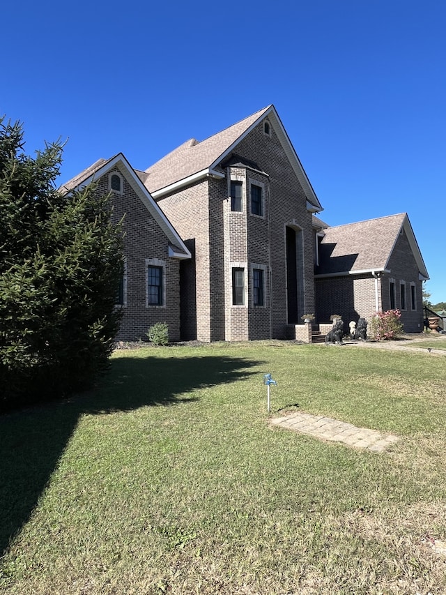 back of property featuring a yard