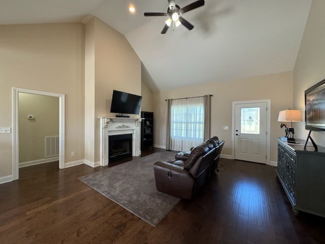 living room with high vaulted ceiling, ceiling fan, and dark wood-type flooring