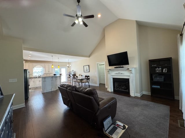 living room featuring high vaulted ceiling, dark hardwood / wood-style flooring, and ceiling fan