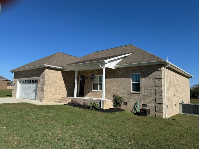 view of side of property with a garage, a yard, and central AC