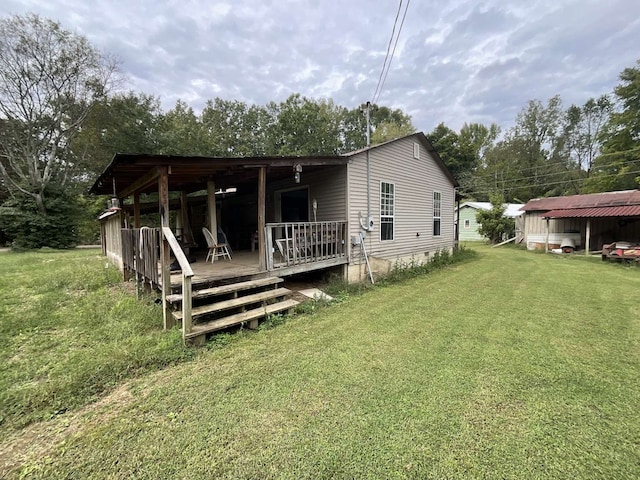 rear view of property with a deck and a lawn