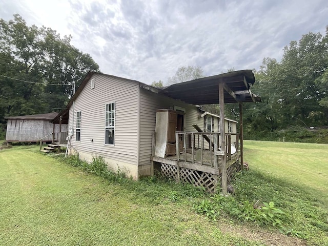 view of side of home with a shed, a lawn, and a wooden deck