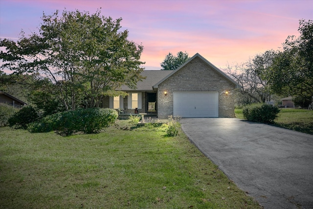 view of front of home featuring a garage and a yard