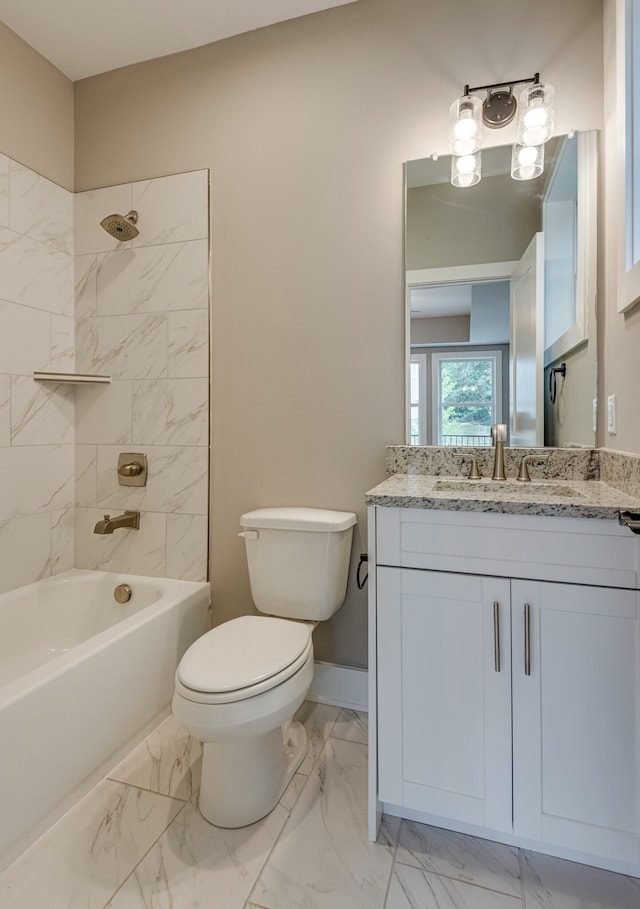 full bathroom with tiled shower / bath, vanity, and toilet