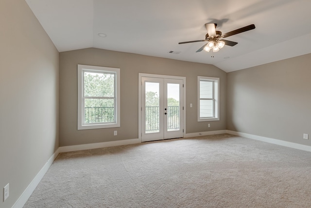 carpeted empty room with ceiling fan, french doors, and vaulted ceiling